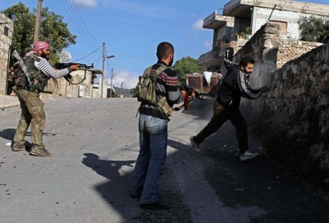 Free Syrian Army members fire on a man they suspect to be from the pro-government forces during a combing operation in Harem town