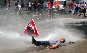 Man is hit by a jet of water as riot police use a water cannon to disperse demonstrators during a protest against Turkey's PM Erdogan and his ruling AKP in central Ankara