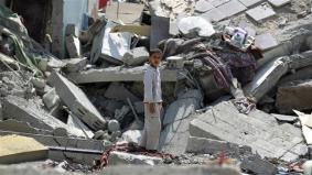 A boy stands in the rubble of buildings destroyed during Saudi airstrikes in the Yemen