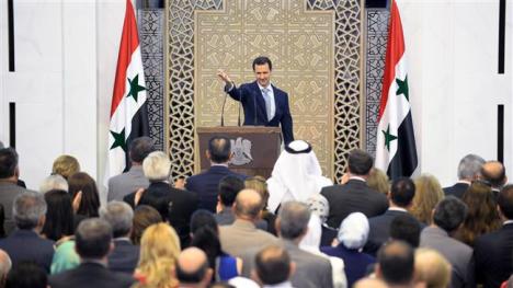 A handout picture released on July 26, 2015 by the official Syrian Arab News Agency (SANA) shows President Bashar al-Assad waving to the crowd following a speech in the capital Damascus. (AFP Photo)